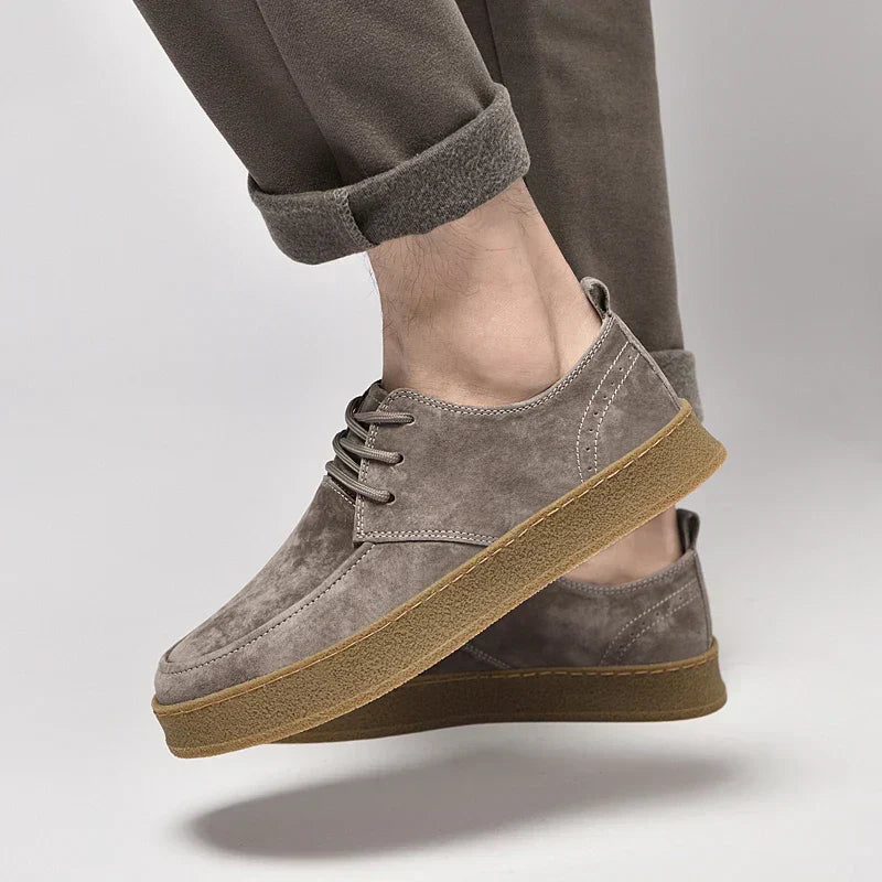 Chaussures en daim gris pour homme, semelle en caoutchouc marron, style décontracté, pantalon retroussé, mode masculine élégante.