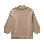 Pull en maille beige à col montant, manches longues et coupe ample. Mode automne-hiver, vêtement chaud et confortable pour femme.