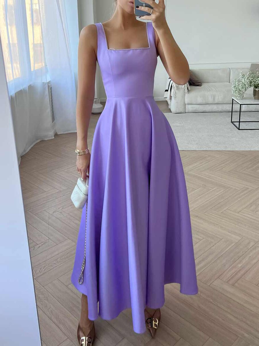 Robe longue violette élégante avec décolleté carré, portée par une femme dans un salon moderne. Mode féminine, tenue de soirée chic.