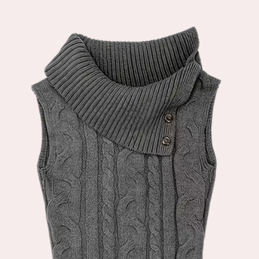 Gilet sans manches gris en tricot torsadé avec col roulé asymétrique et boutons décoratifs. Mode hiver, style élégant et confortable.