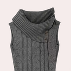 Gilet sans manches gris en tricot torsadé avec col roulé asymétrique et boutons décoratifs. Mode hiver, style élégant et confortable.
