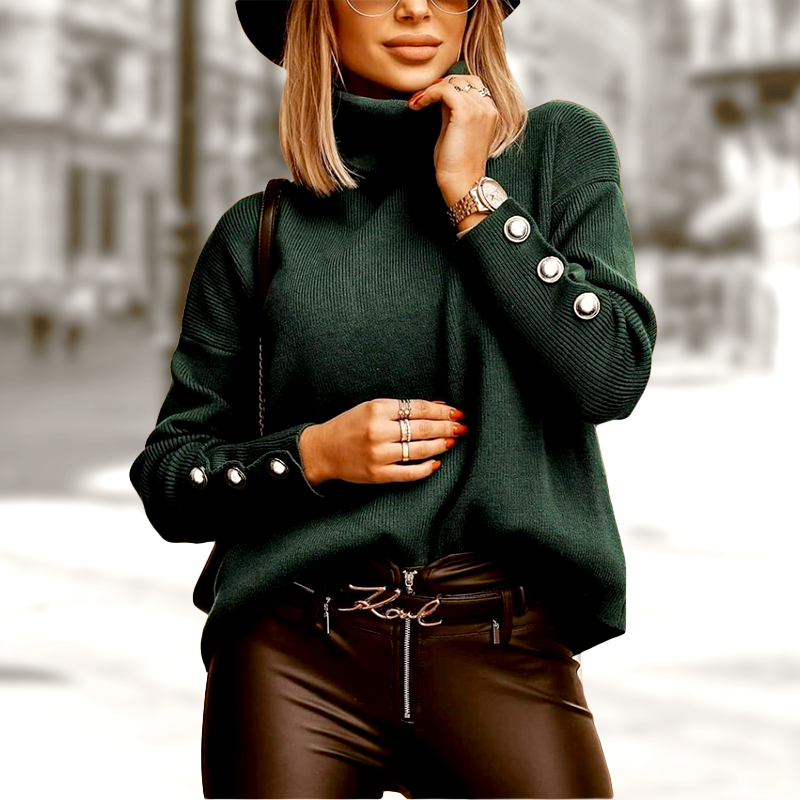 Femme élégante en pull vert à col roulé avec boutons, portant un chapeau noir et lunettes de soleil, mode urbaine chic, rue floue en arrière-plan.