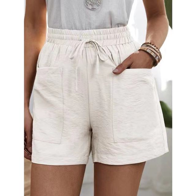 Short en lin blanc pour femme avec taille élastique et poches avant. Style décontracté estival, parfait pour la mode féminine tendance.