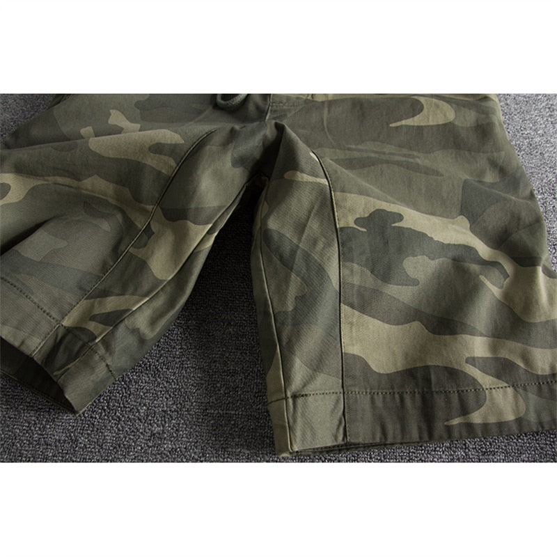 Short camouflage vert pour homme sur fond gris, motif militaire, style décontracté, idéal pour l'été et les activités en plein air.