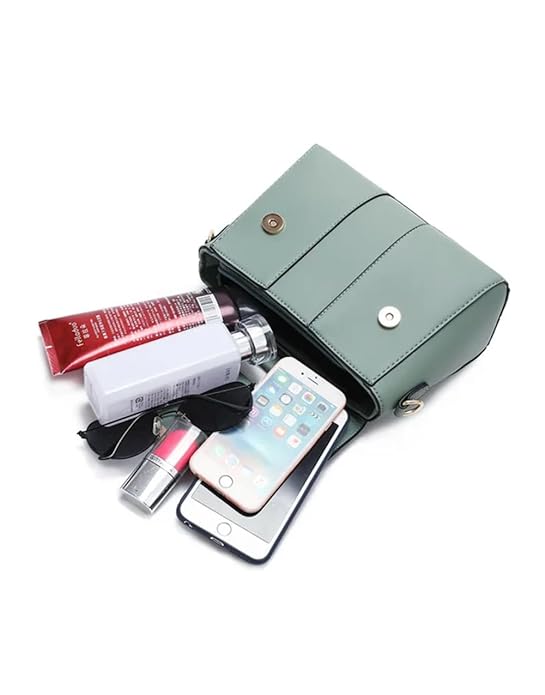 Sac à main vert en cuir avec téléphone, lunettes de soleil, rouge à lèvres et produits de beauté visibles, accessoires mode femme tendance.