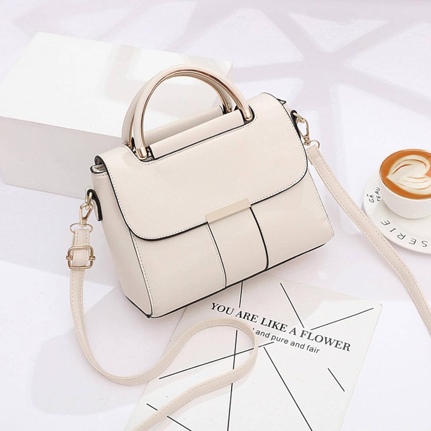 Sac à main en cuir blanc élégant sur fond minimaliste, avec une tasse de café et un magazine. Accessoire mode femme, design moderne et chic.