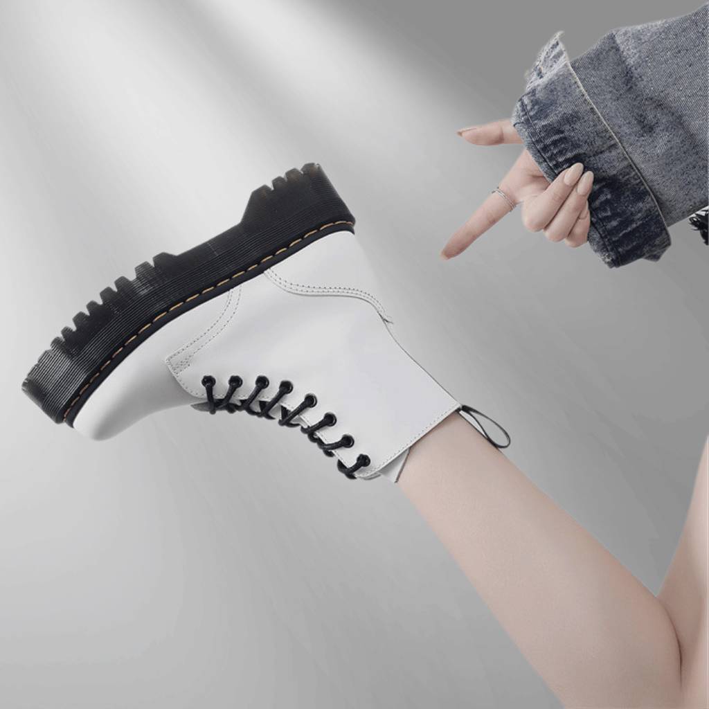 Botte blanche à lacets avec semelle épaisse noire, style punk, portée avec un jean décontracté. Mode tendance, chaussures robustes.