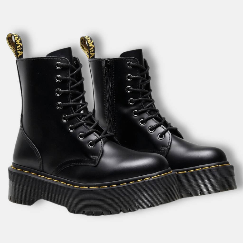 Bottes noires en cuir à lacets avec semelles épaisses et surpiqûres jaunes, style punk rock. Chaussures tendance pour mode alternative et urbaine.