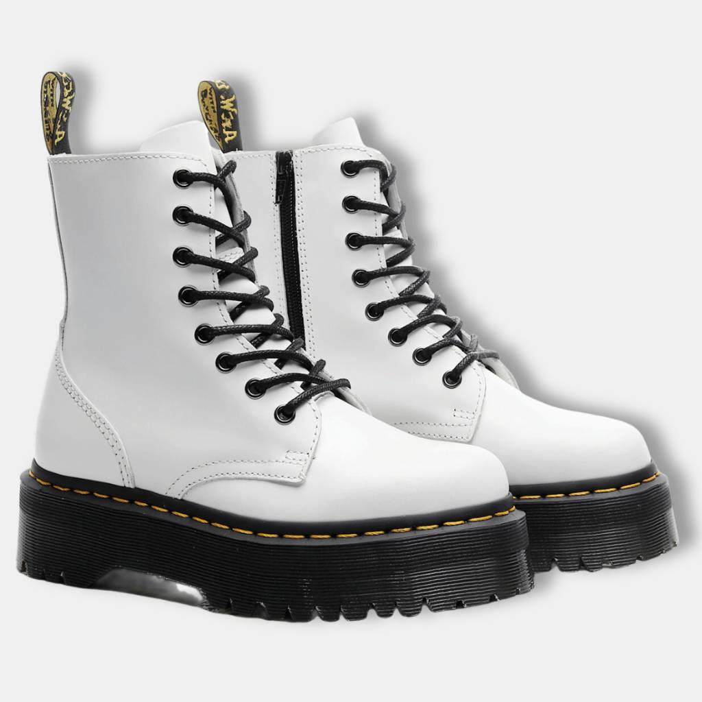 Bottes blanches à plateforme avec lacets noirs, semelle épaisse noire, coutures jaunes, style punk rock. Chaussures tendance pour mode alternative.