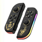 Manettes Joy-Con noires avec motifs dorés et lumières LED arc-en-ciel, inspirées par un jeu vidéo populaire, accessoires Nintendo Switch.