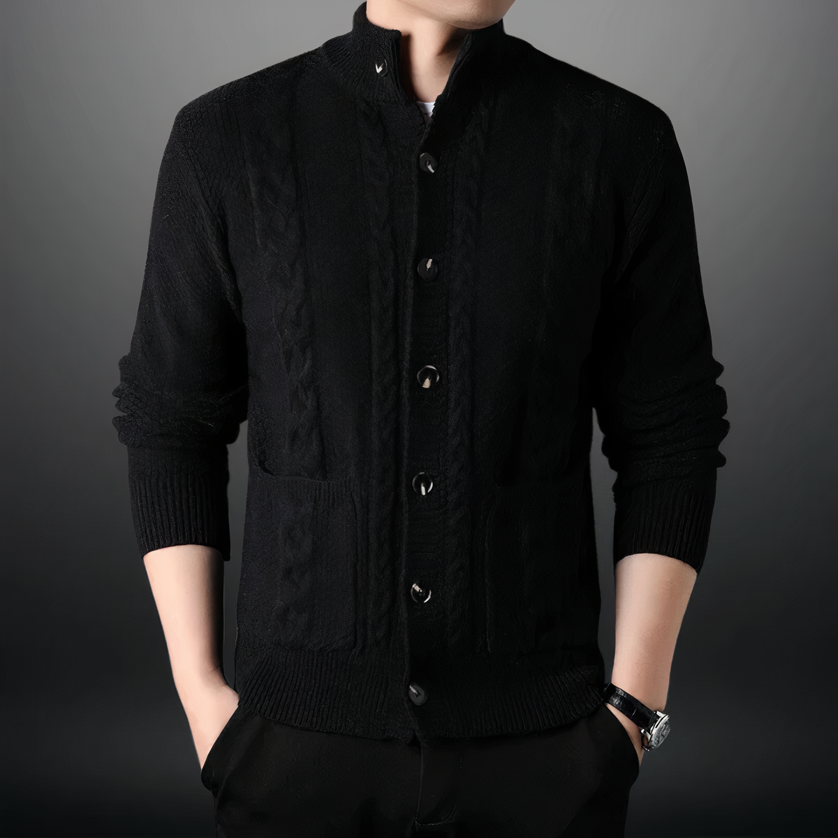 Homme portant un cardigan noir élégant, manches longues, avec boutons et poches, sur fond gris. Mode masculine, tenue chic et moderne.