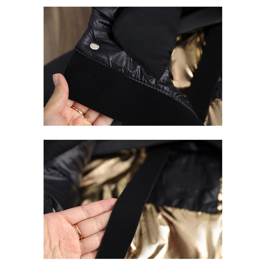 Main tenant une doudoune noire avec doublure dorée et bouton argenté, gros plan sur les détails du tissu et de la couture. Mode hiver élégante.