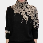 Pull noir à col roulé avec motif floral beige, manches longues. Élégant et tendance, idéal pour l'automne et l'hiver. Mode féminine chic.