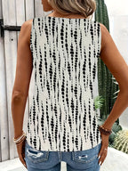 Femme portant un débardeur à motifs noirs et blancs, dos visible, devant une porte en bois et un cactus. Mode estivale, style décontracté.