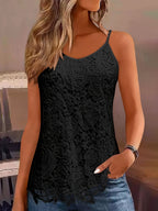 Femme portant un débardeur en dentelle noire avec motif floral, cheveux blonds ondulés, bracelet argenté, ambiance décontractée.