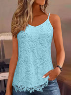 Femme portant un débardeur en dentelle bleu clair avec motif floral, style décontracté, idéal pour l'été. Mode féminine tendance et élégante.