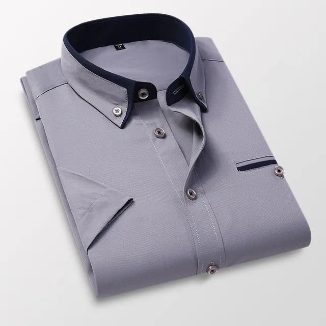 Chemise homme grise élégante, col contrasté bleu marine, manches longues, boutons argentés, style formel, mode masculine, vêtement chic.