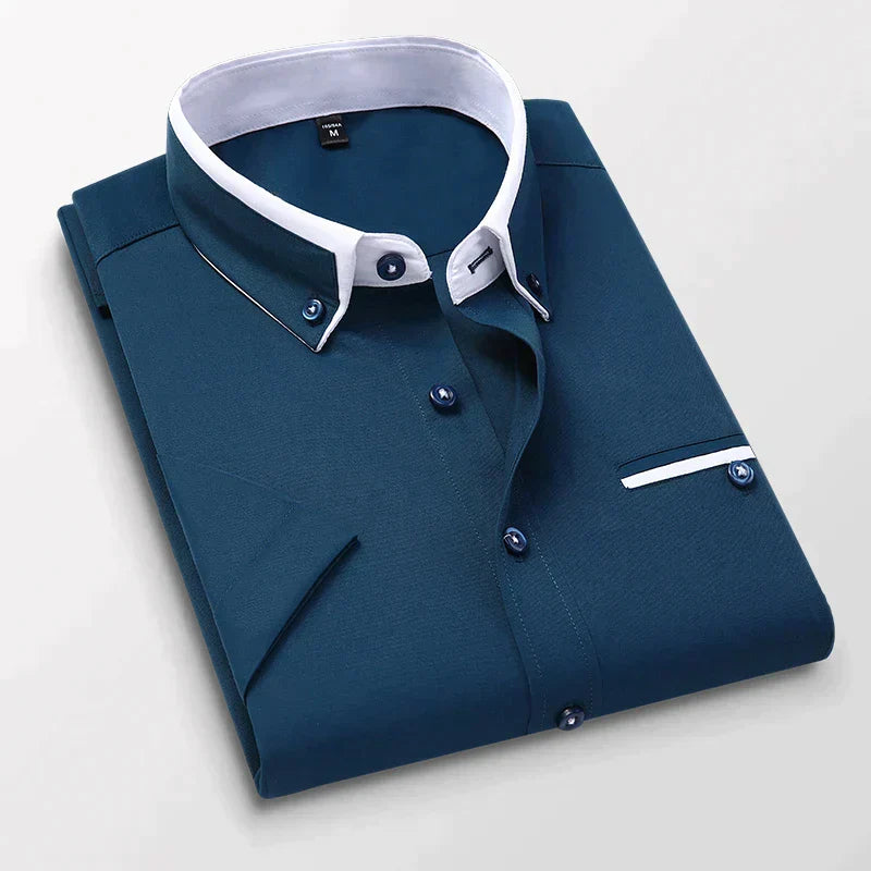 Chemise homme bleu marine élégante, col blanc contrastant, boutons assortis, poche poitrine, style formel, mode masculine, vêtement tendance.