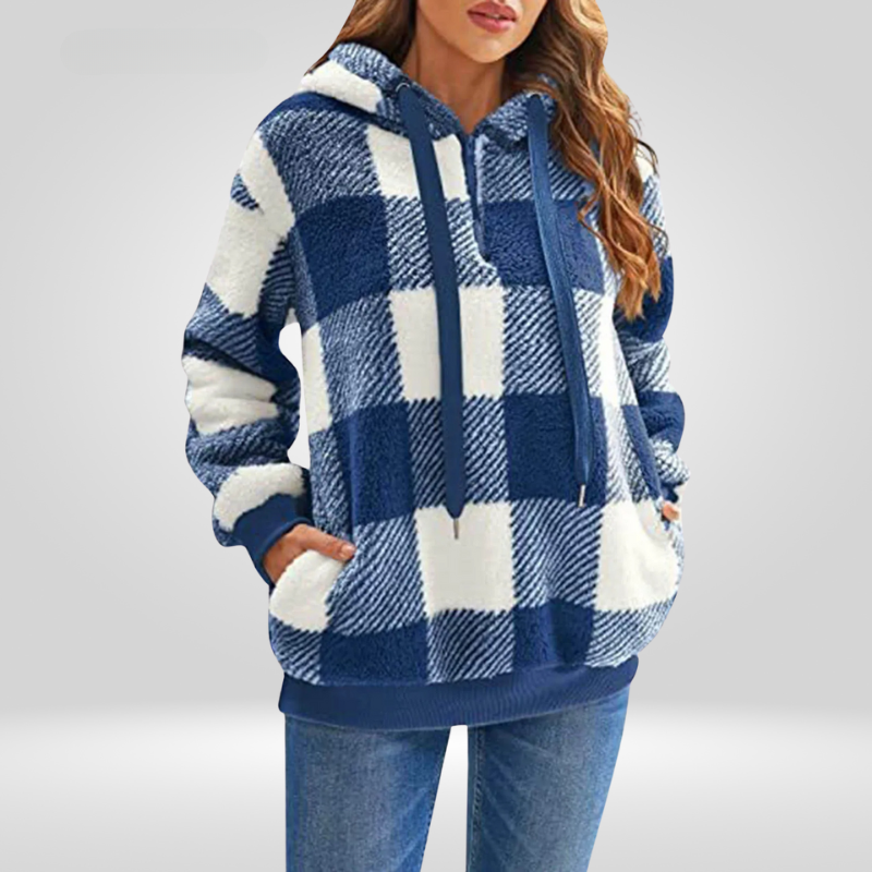 Femme portant un sweat à capuche à carreaux bleu et blanc, manches longues, poches avant, style décontracté, mode automne-hiver.