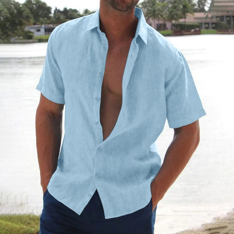 Homme portant une chemise en lin bleu clair, manches courtes, devant un lac. Mode estivale décontractée, style masculin élégant.