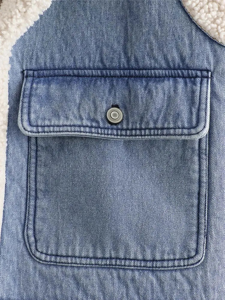 Poche en jean bleu avec bouton pression sur fond de tissu en laine blanche. Mode, vêtements en denim, détails de couture.