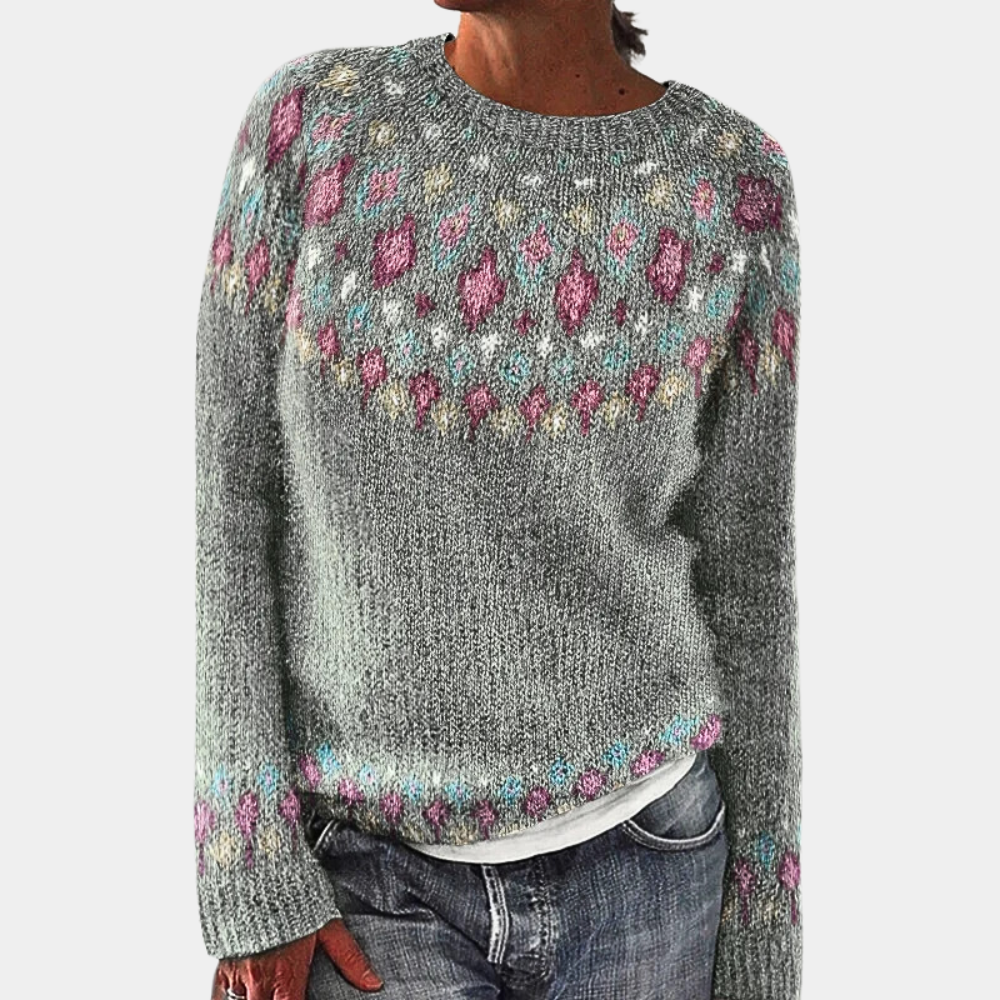 Pull en laine gris avec motifs colorés géométriques, manches longues, col rond, porté par une personne. Mode hiver, style décontracté et tendance.