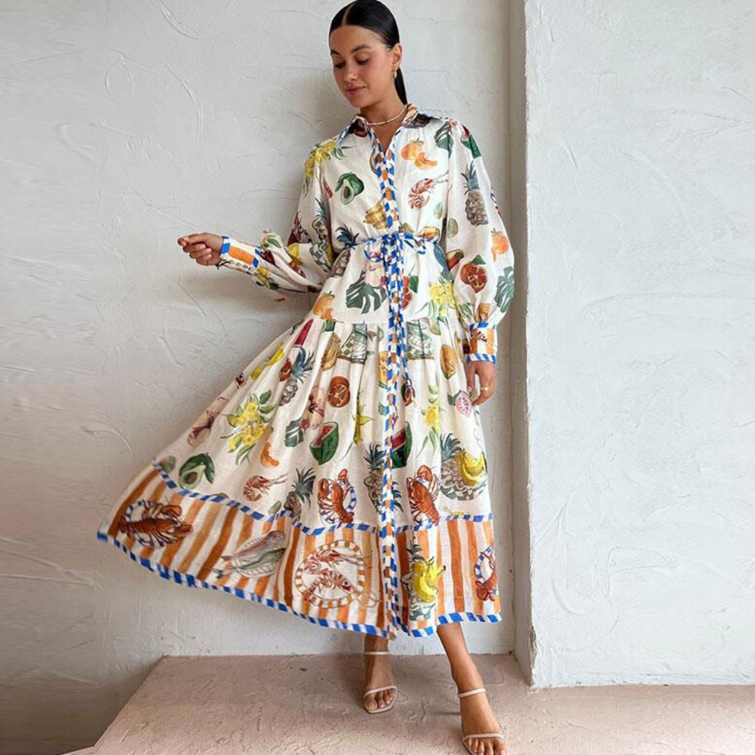 Robe longue imprimée tropicale, femme posant élégamment, motifs colorés de feuilles et animaux, style bohème chic, fond blanc texturé.