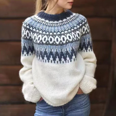 Femme portant un pull en laine tricoté à motifs nordiques bleus et blancs, manches longues, col rond, style hiver, mode décontractée.