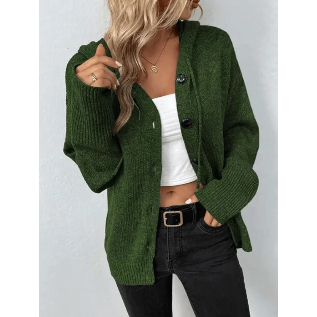 Femme portant un cardigan vert en laine, débardeur blanc et jean noir. Mode automne, style décontracté, tendance féminine.