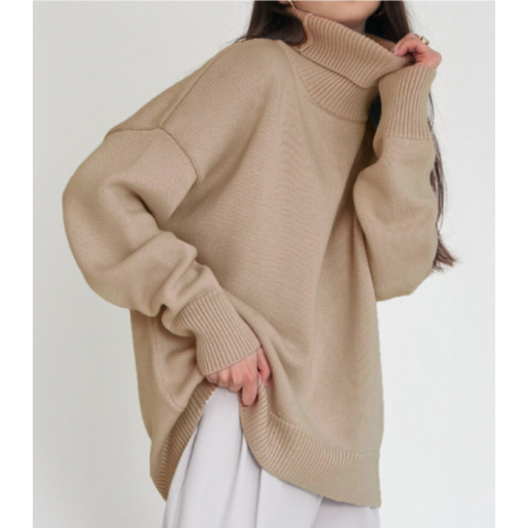 Femme portant un pull beige à col roulé oversize, manches longues, style décontracté, mode automne-hiver, tendance vêtements chauds.