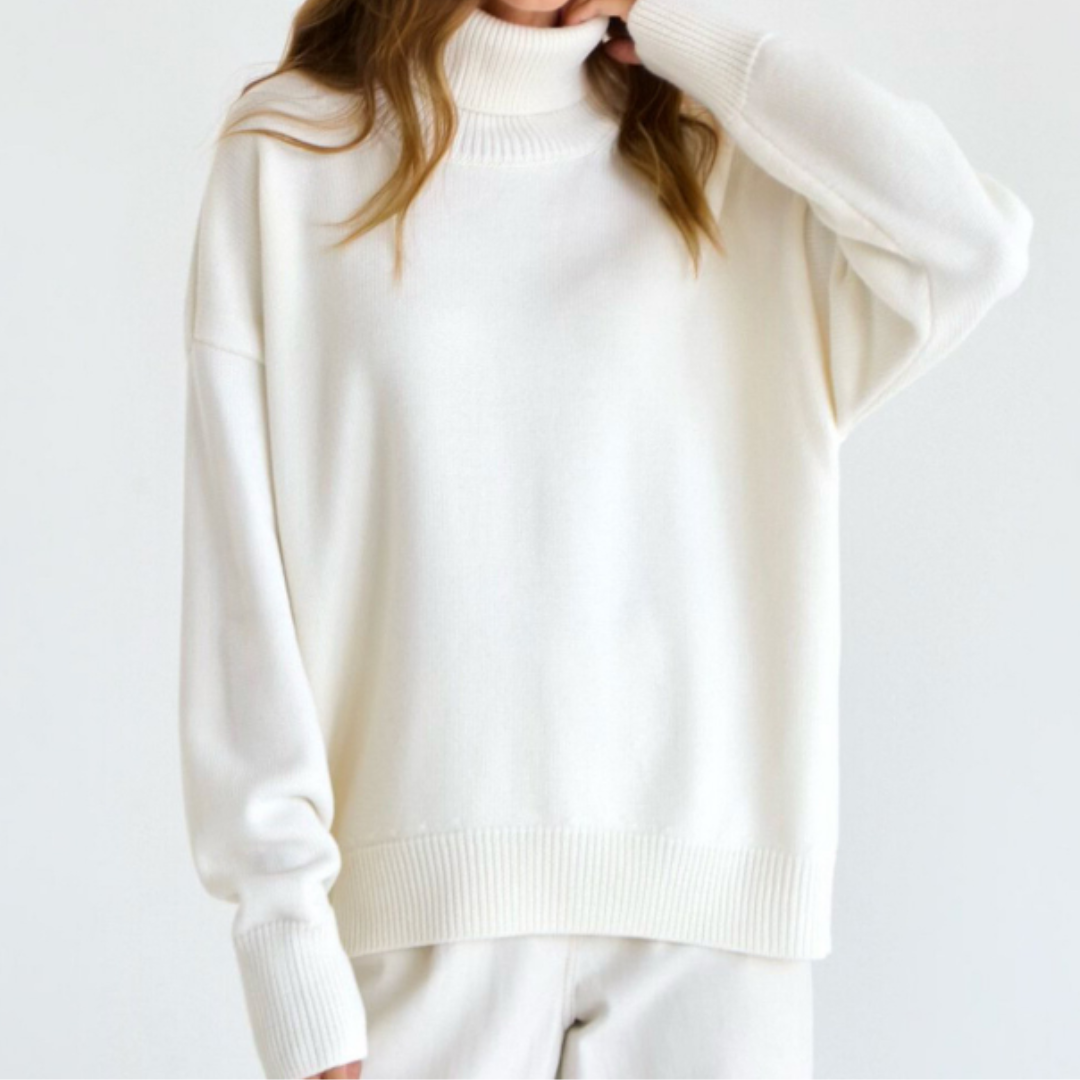Femme portant un pull blanc à col roulé, manches longues, style décontracté. Mode automne-hiver, tenue élégante et confortable.