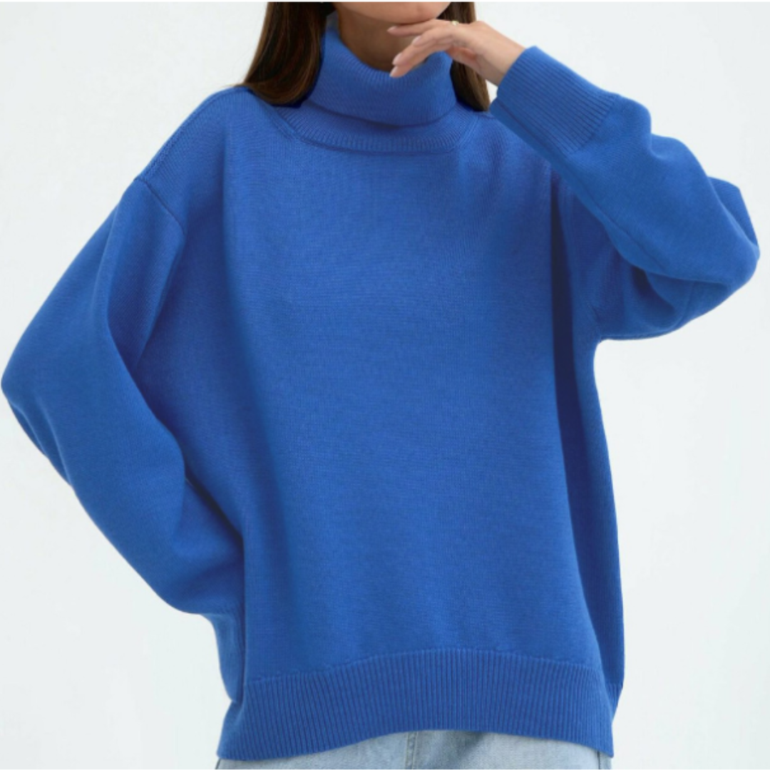 Femme portant un pull bleu oversize à col roulé, manches longues, style décontracté. Mode automne-hiver, tendance vêtements confortables.