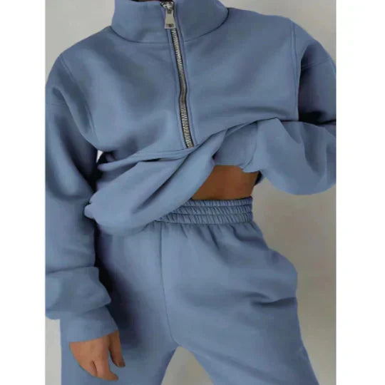 Personne portant un survêtement bleu clair avec fermeture éclair, style décontracté et moderne. Mode automne-hiver, confort et tendance.