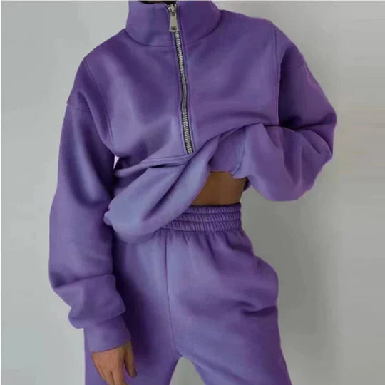 Personne portant un ensemble de survêtement violet avec fermeture éclair, style décontracté et moderne. Mode féminine, tendance automne-hiver.