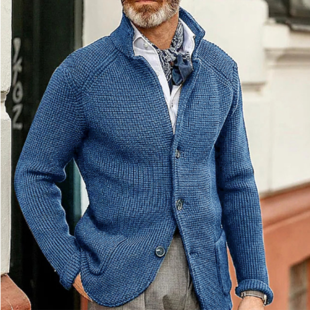 Homme portant un cardigan bleu en maille, chemise blanche et cravate, style élégant et décontracté, mode masculine automne-hiver.
