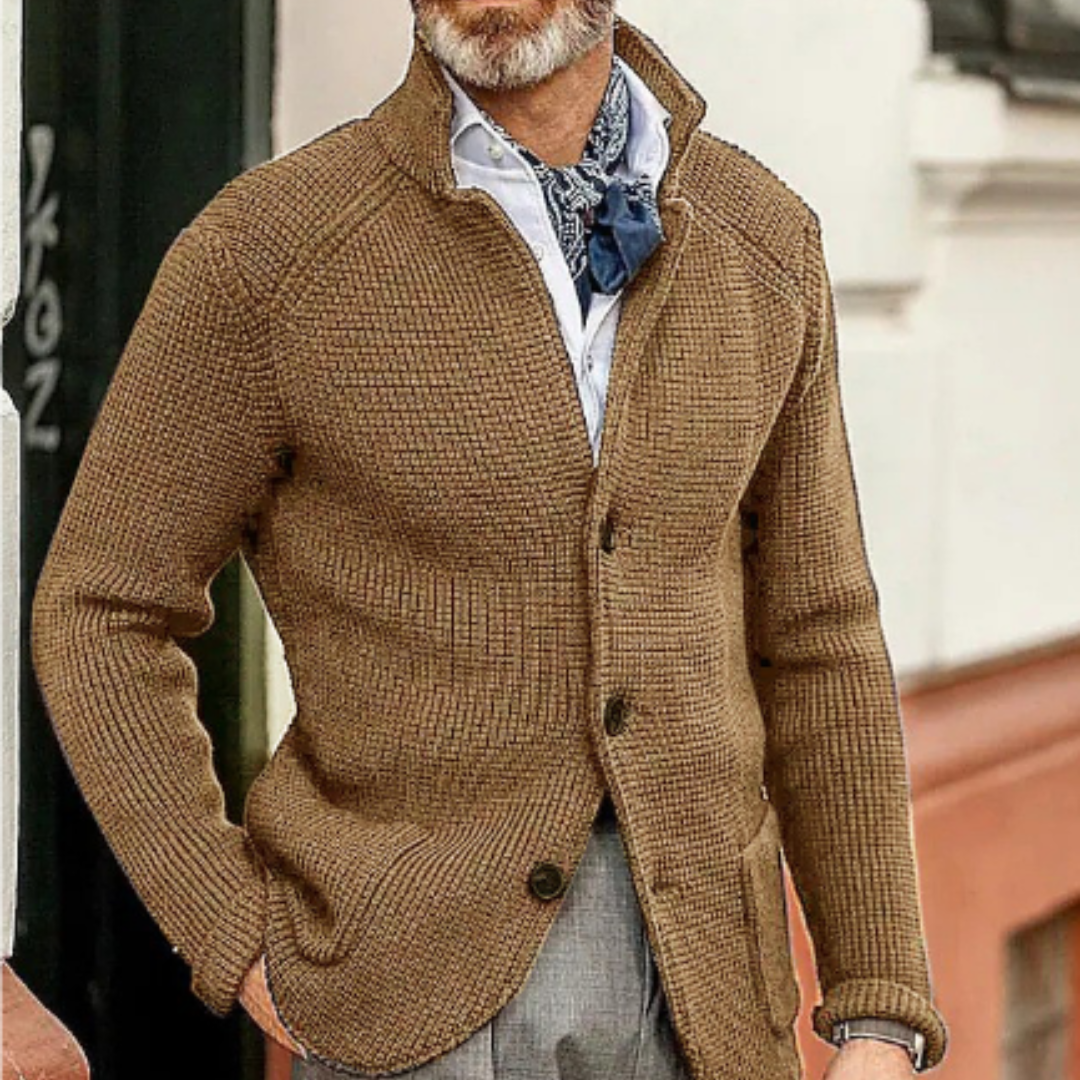 Homme portant un cardigan marron texturé, chemise blanche et foulard bleu, style élégant et décontracté, mode masculine automne-hiver.