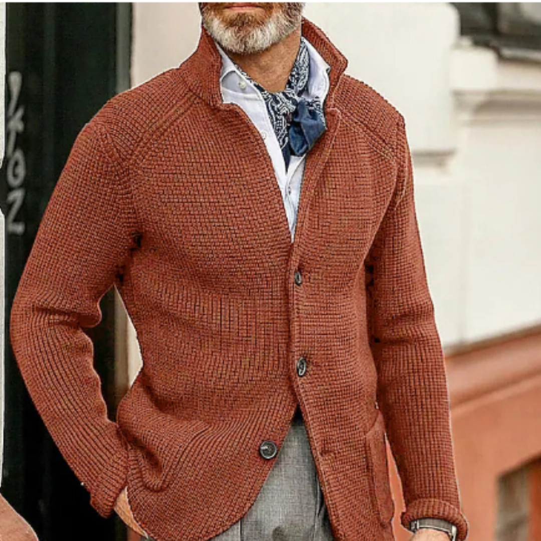 Homme portant un cardigan en maille marron, chemise blanche et foulard bleu, style élégant et décontracté, mode masculine automne-hiver.