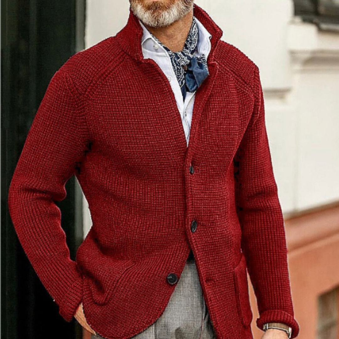 Homme portant un cardigan rouge élégant, chemise blanche et foulard bleu. Mode masculine automne, style chic et décontracté.