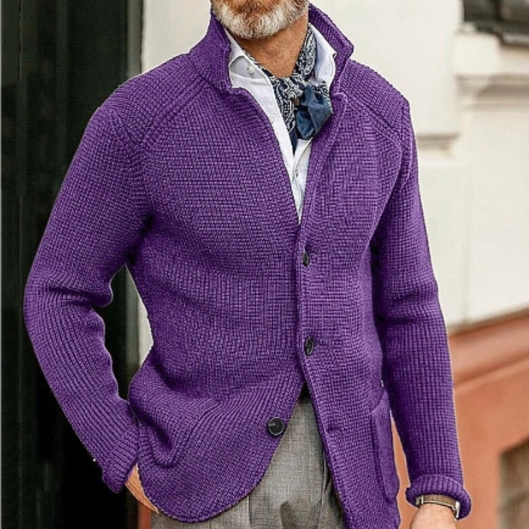Homme portant un cardigan violet en tricot, chemise blanche et foulard bleu, style élégant et moderne, mode masculine automne-hiver.