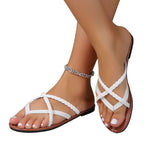 Sandales blanches tressées pour femme, pieds avec vernis blanc, bracelet de cheville argenté. Mode estivale, chaussures confortables et élégantes.