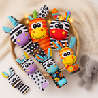 Jouets en tissu colorés pour bébés dans un panier, motifs zèbre et carotte, sur fond de couverture beige, avec un éléphant en peluche à côté.