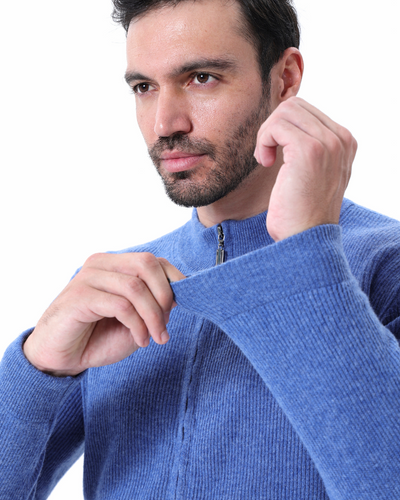 Homme portant un pull bleu en laine, fermant la fermeture éclair. Mode masculine, vêtement d'hiver, style décontracté, confort et élégance.