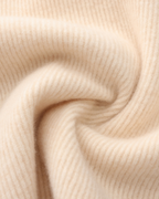 Texture douce de tissu en cachemire beige, gros plan. Motif côtelé, textile luxueux et chaud, idéal pour vêtements d'hiver élégants.