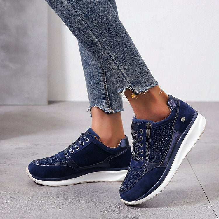Chaussures de sport bleues pour femmes, élégantes et confortables, portées avec un jean. Sneakers tendance avec semelle blanche, style décontracté.