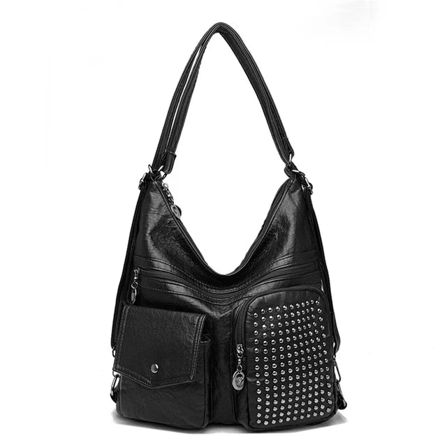 Sac à main noir en cuir avec clous argentés, poches avant zippées et bandoulière ajustable. Accessoire mode femme élégant et tendance.