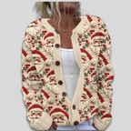 Gilet en tricot beige avec motifs de Noël, incluant des Pères Noël et des houx rouges, porté par une femme en débardeur blanc. Mode festive hiver.