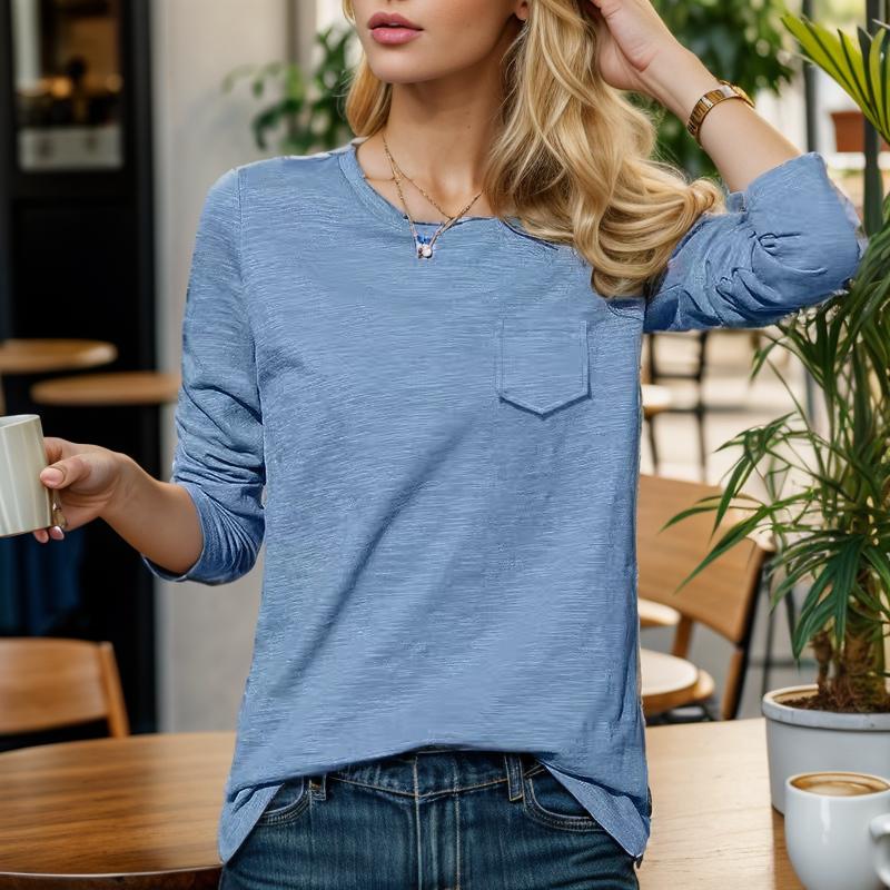 Femme en pull bleu, tenant une tasse de café dans un café moderne. Mode décontractée, ambiance détendue, intérieur avec plantes vertes.