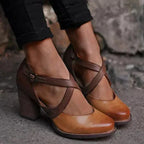 Chaussures à talons marron en cuir, design croisé, portées avec un pantalon noir. Mode élégante, tendance automne, chaussures femme.