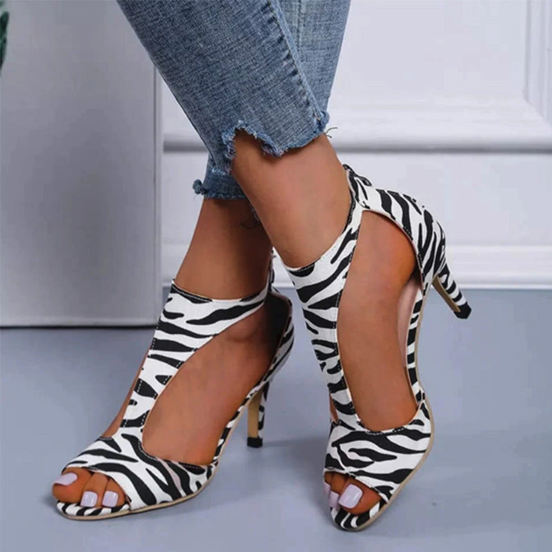 Escarpins à talons hauts motif zèbre, portés avec un jean déchiré. Chaussures tendance, élégantes et modernes pour un look chic et audacieux.