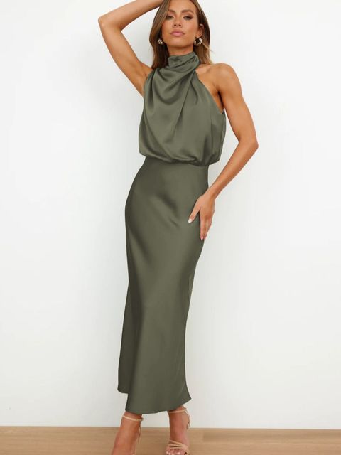Robe longue élégante en satin vert olive, sans manches, col drapé, portée par une femme posant debout. Mode féminine chic et tendance.